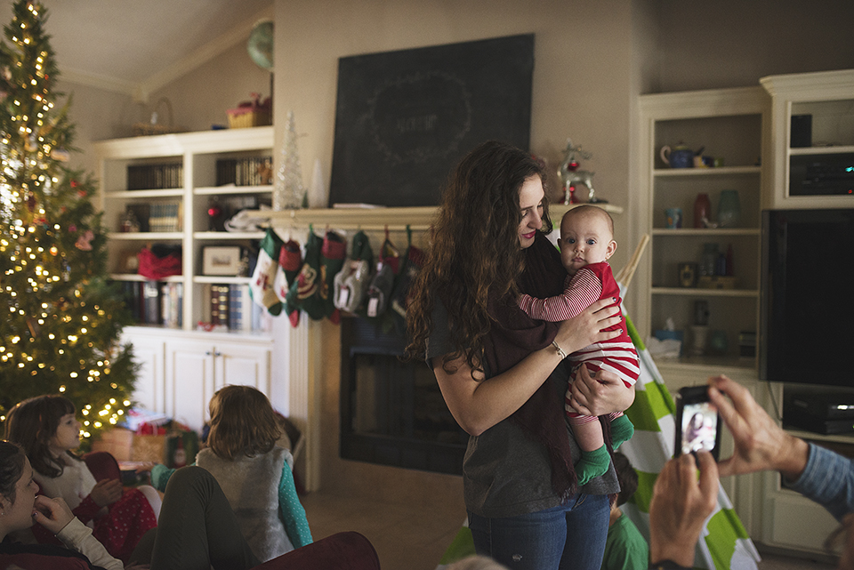 Family Documentary photography, family christmas gathering woman holding baby 