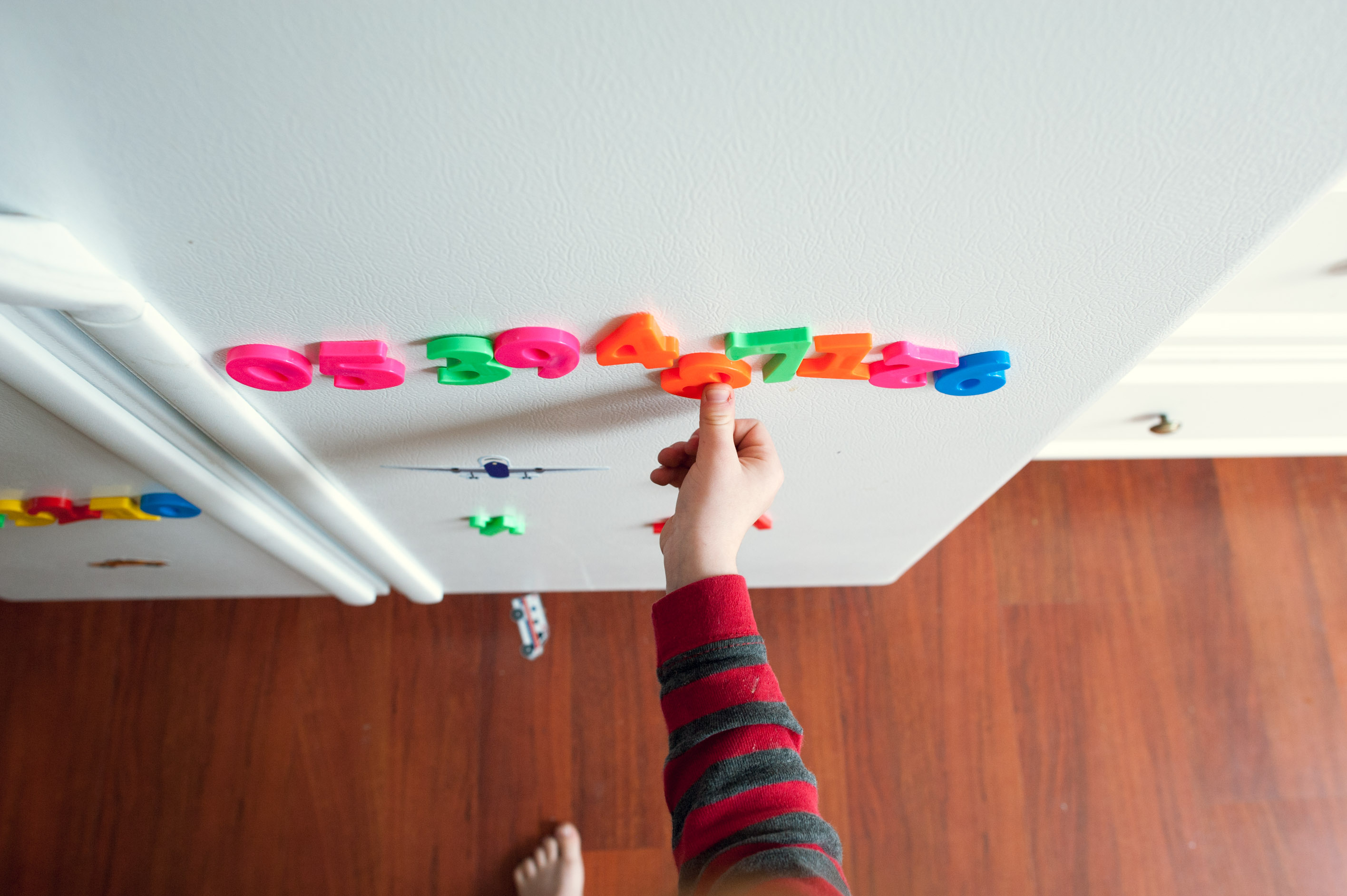 Playing with refrigerator magnets - Family Documentary Photography