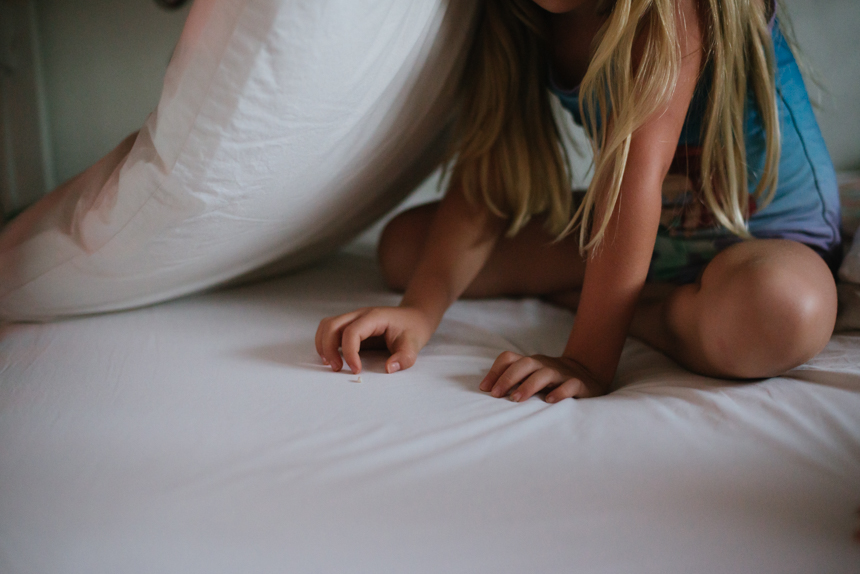 girl scratching at bed sheets -family documentary photography