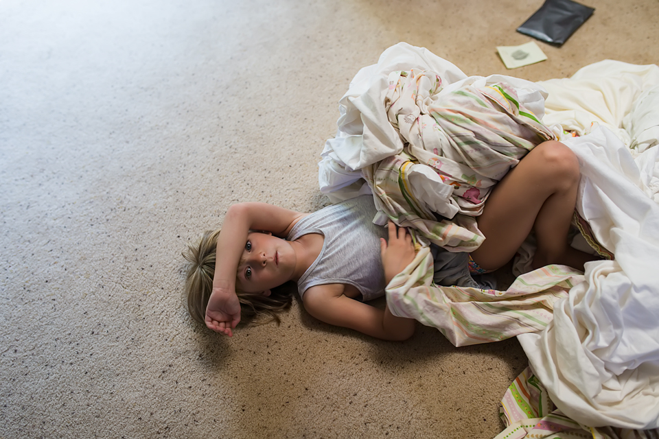 girl on floor with bedding - Family documentary photography