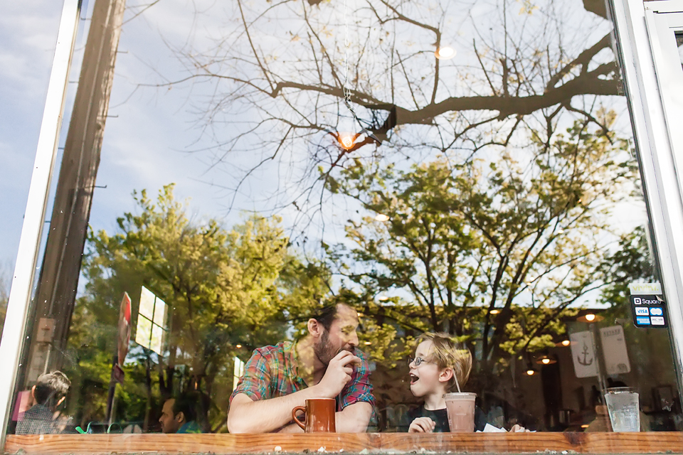 Father and son at coffeeshop through window