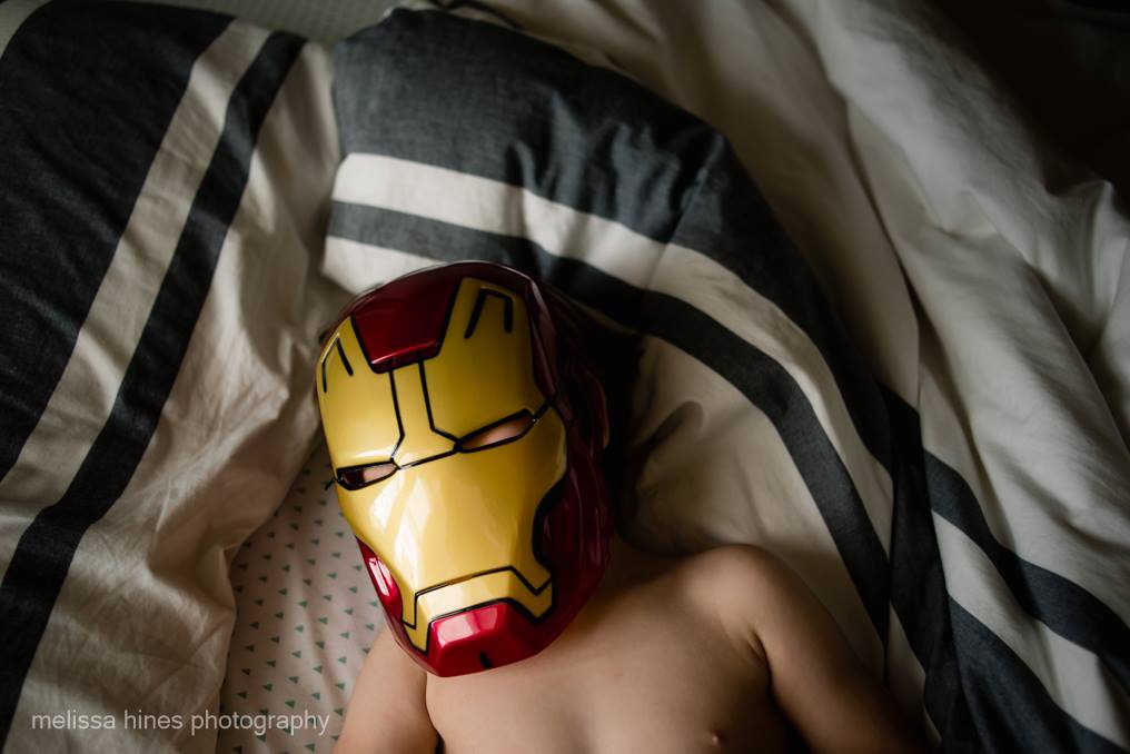 child in iron man mask - baby sleeping in man's lap - Gold Hope Project