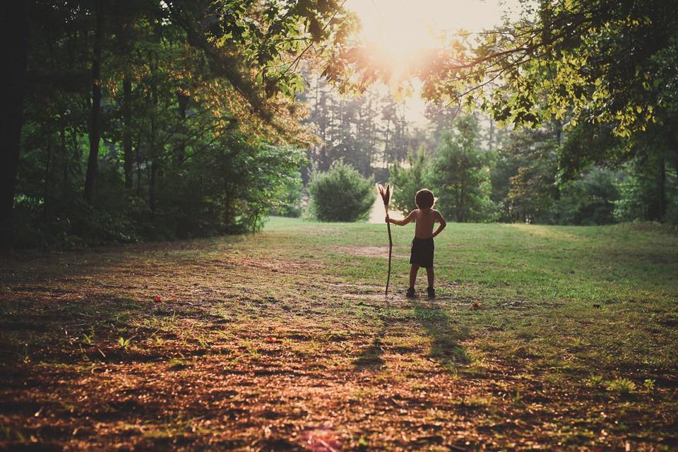 Child with stick in field - Gold Hope Project