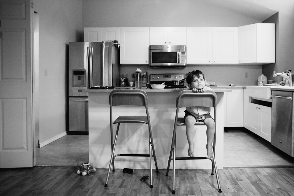 boy looks bored in kitchen - family documentary photography 
