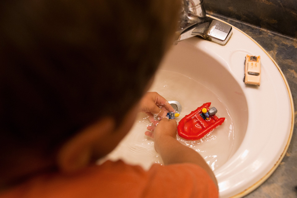 child washes legos -family documentary photography 