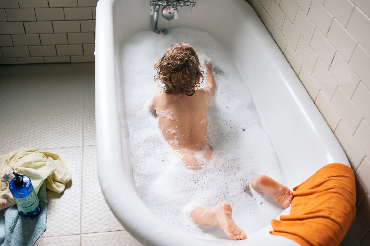 kid plays in bath tub