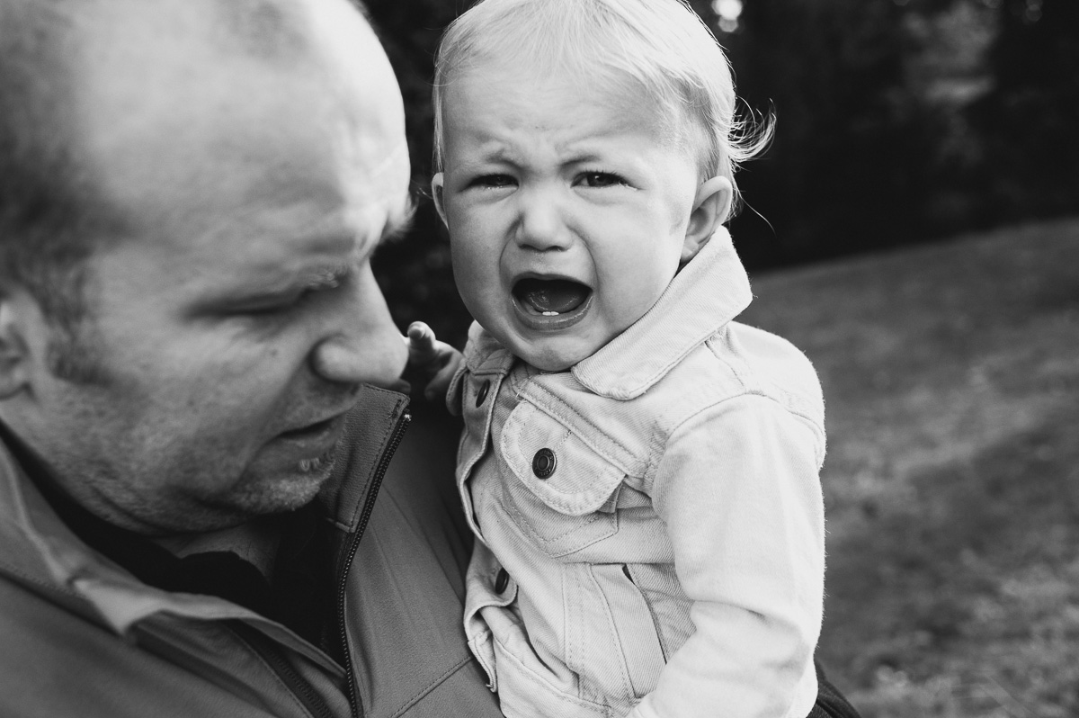 baby yelling while held by father