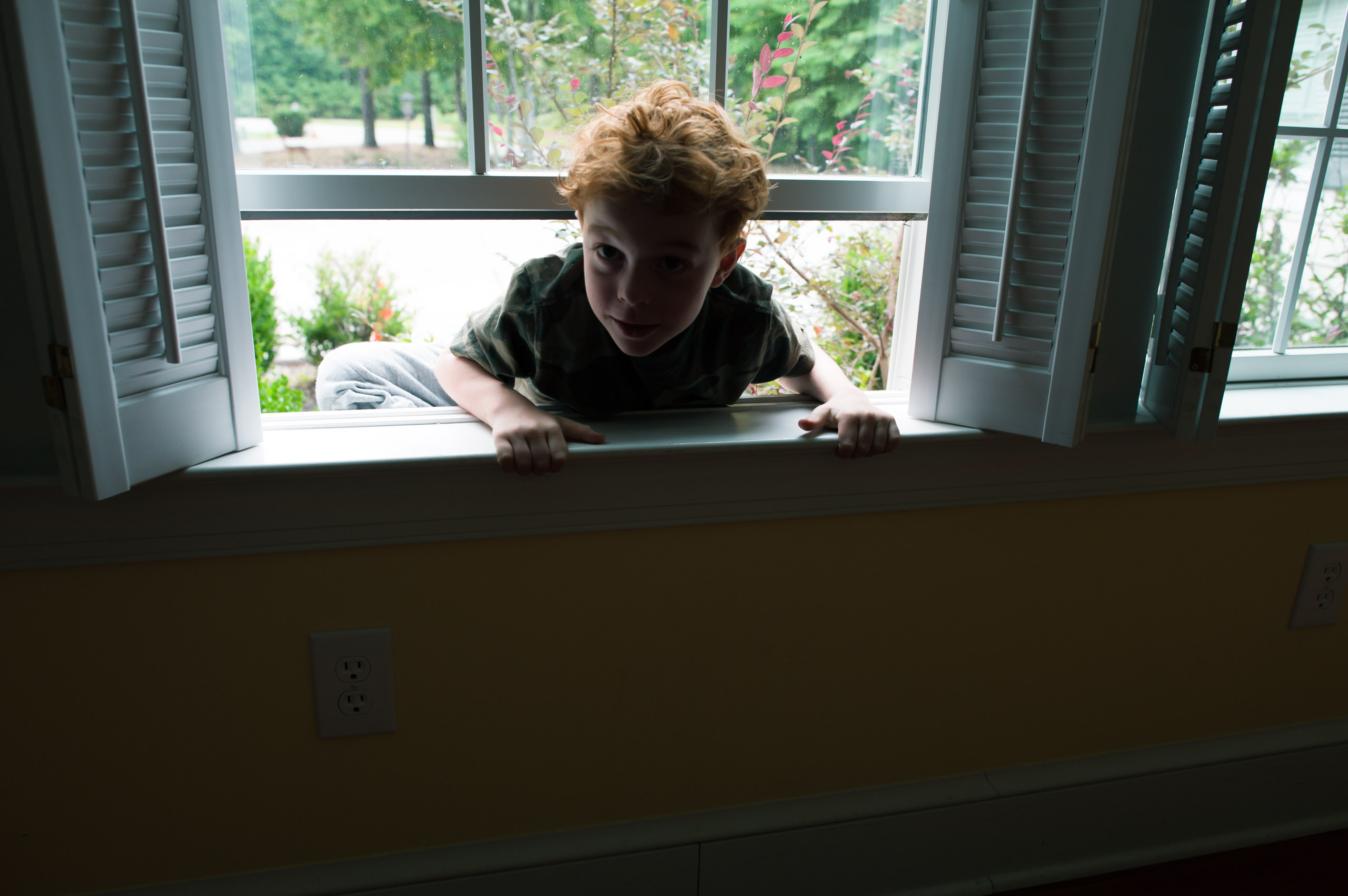 boy climbing through window - Family Documentary Photography