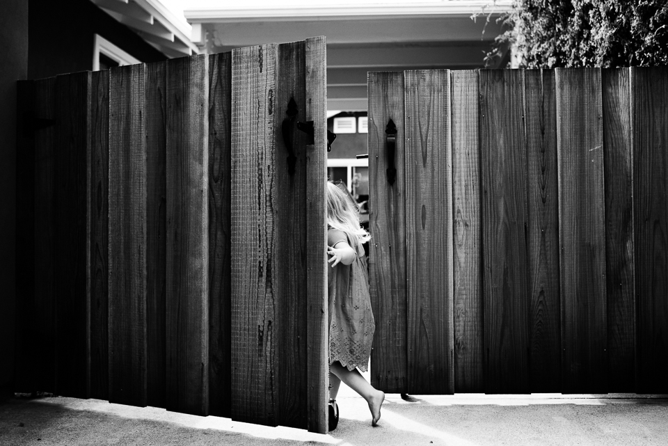 girl running through gate - documentary family photography