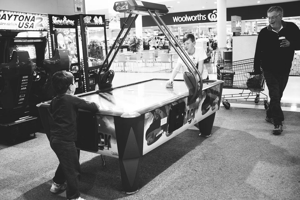 boys playing air hockey - Family Documentary Photography