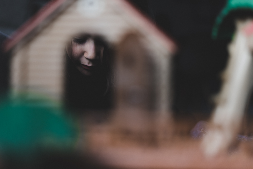 girl peering into to toy door - documentary family photography