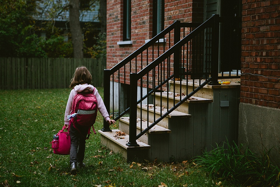 girl coming home with school bag - documentary family photography
