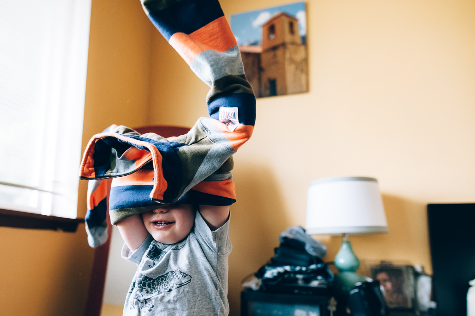 boy putting on sweatshirt - documentary family photography