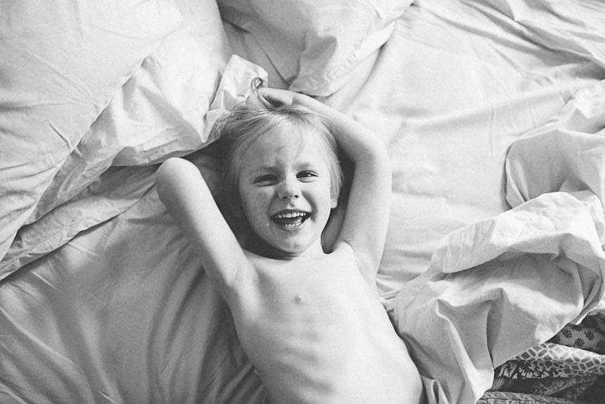 boy laughing in bed - Family Documentary Photography