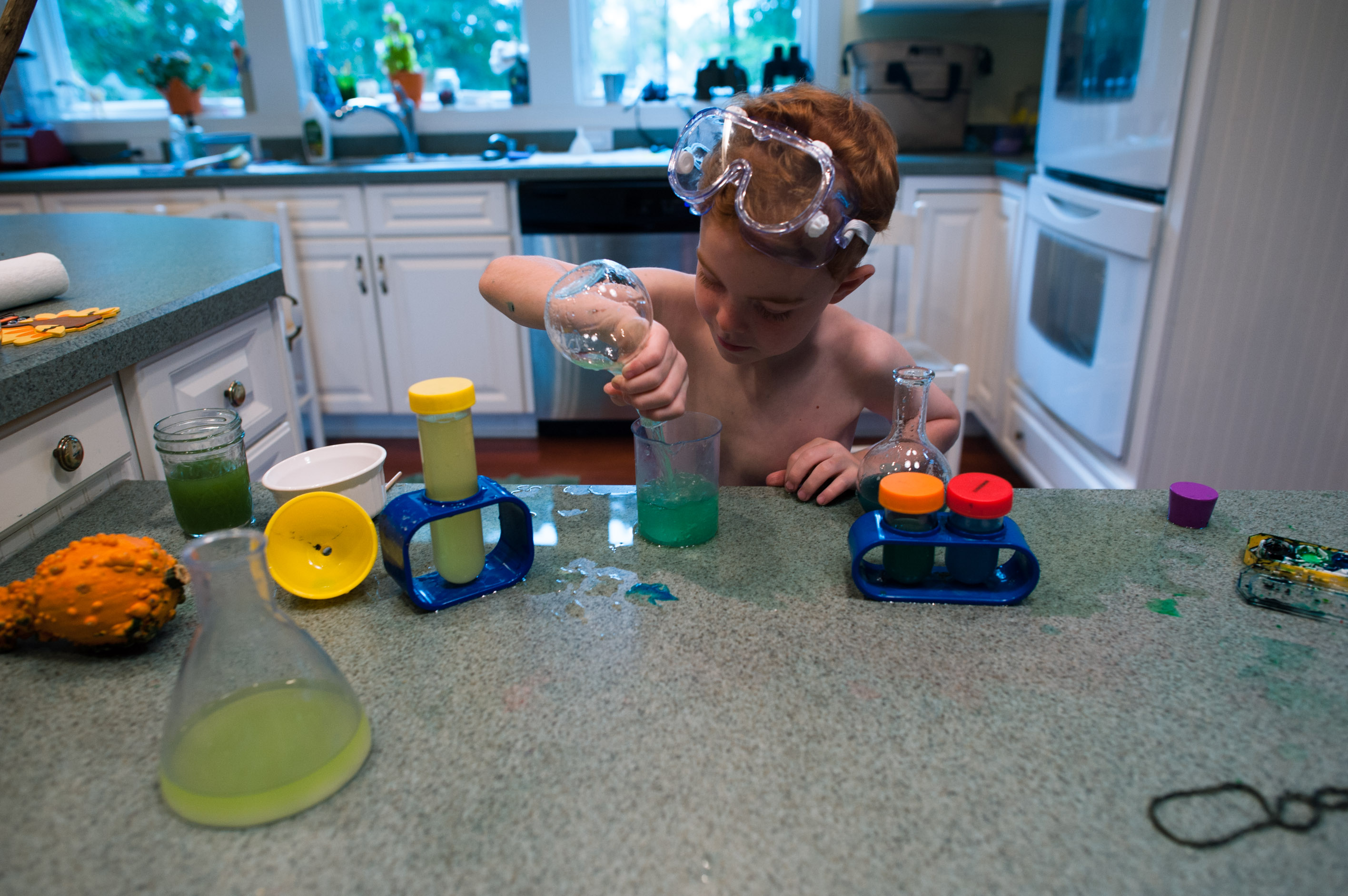 boy with toy chemistry kit - documentary family photography