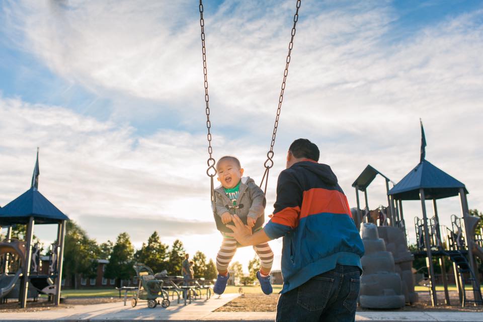 child being pushed on swing