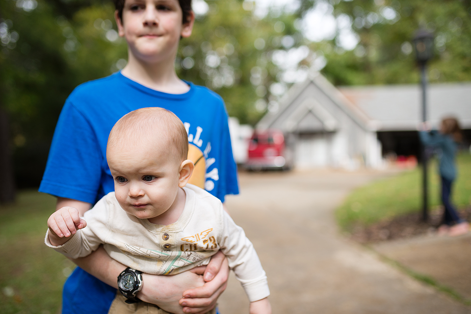 boy carrying baby - Family Documentary Photography