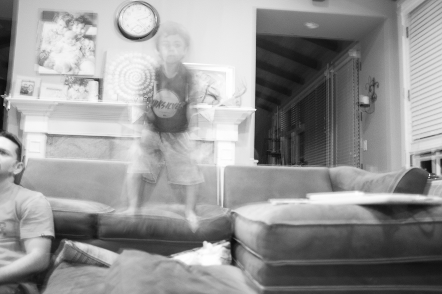 boy jumping on couch - family documentary photography