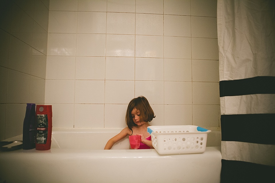 girl plays quietly in tub - Family Documentary Photography