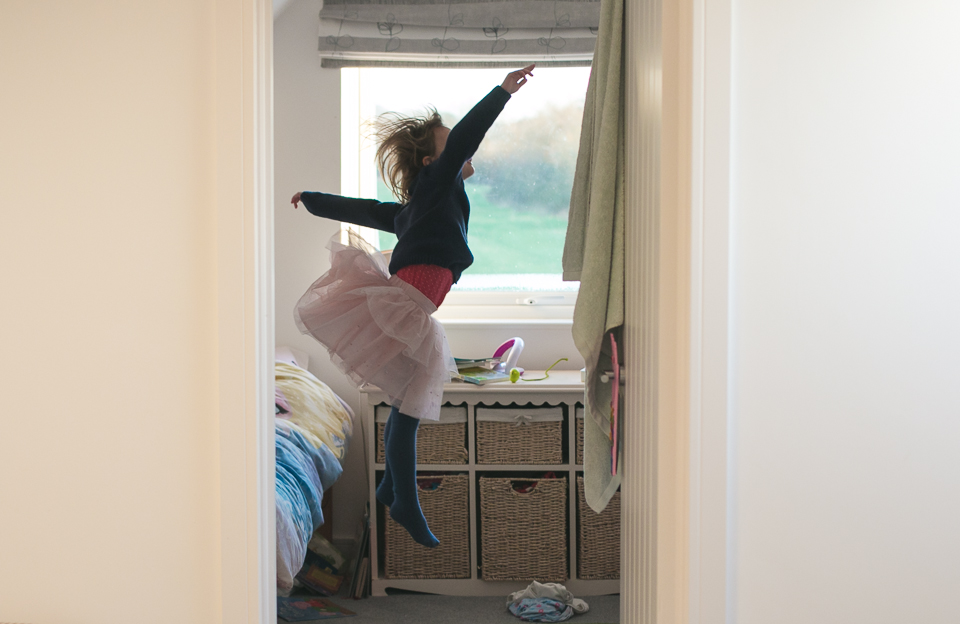 girl in skirt jumps off bed - Family Documentary Photography