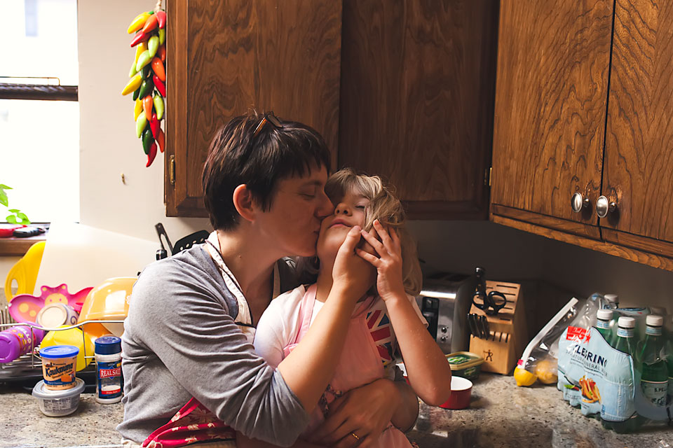 Self portrait of mother with daughter in kitchen