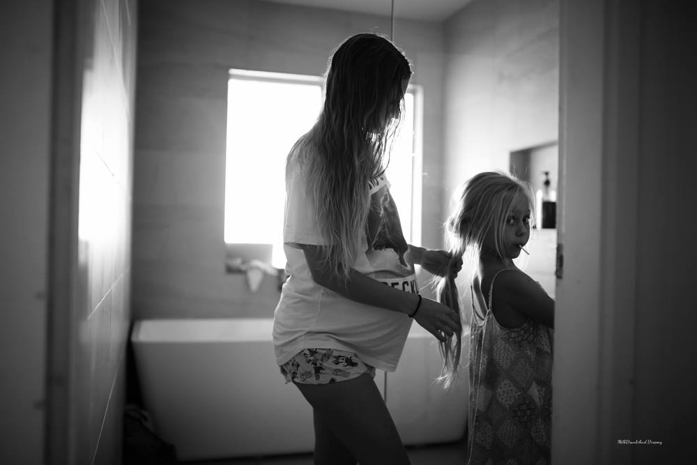 mother brushes daughters hair