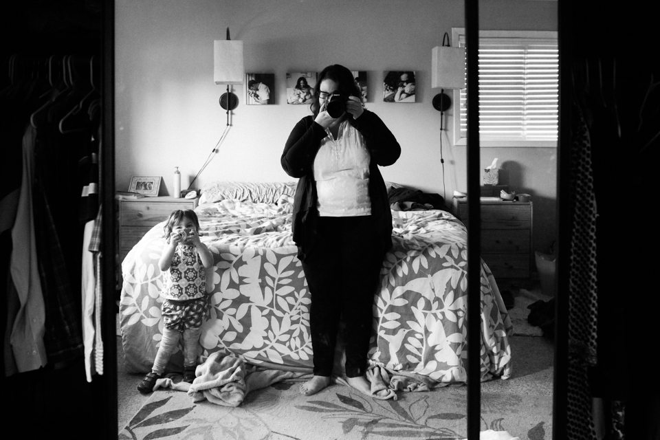 self portrait of mother with daughter taking photo in mirror