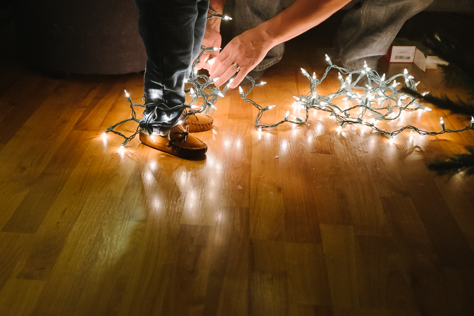 Boy's feet wrapped in Christmas lights - Family Documentary Photography