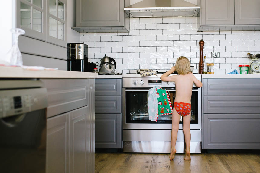 boy in holiday underwear peeks over stovetop - Family Documentary Photography