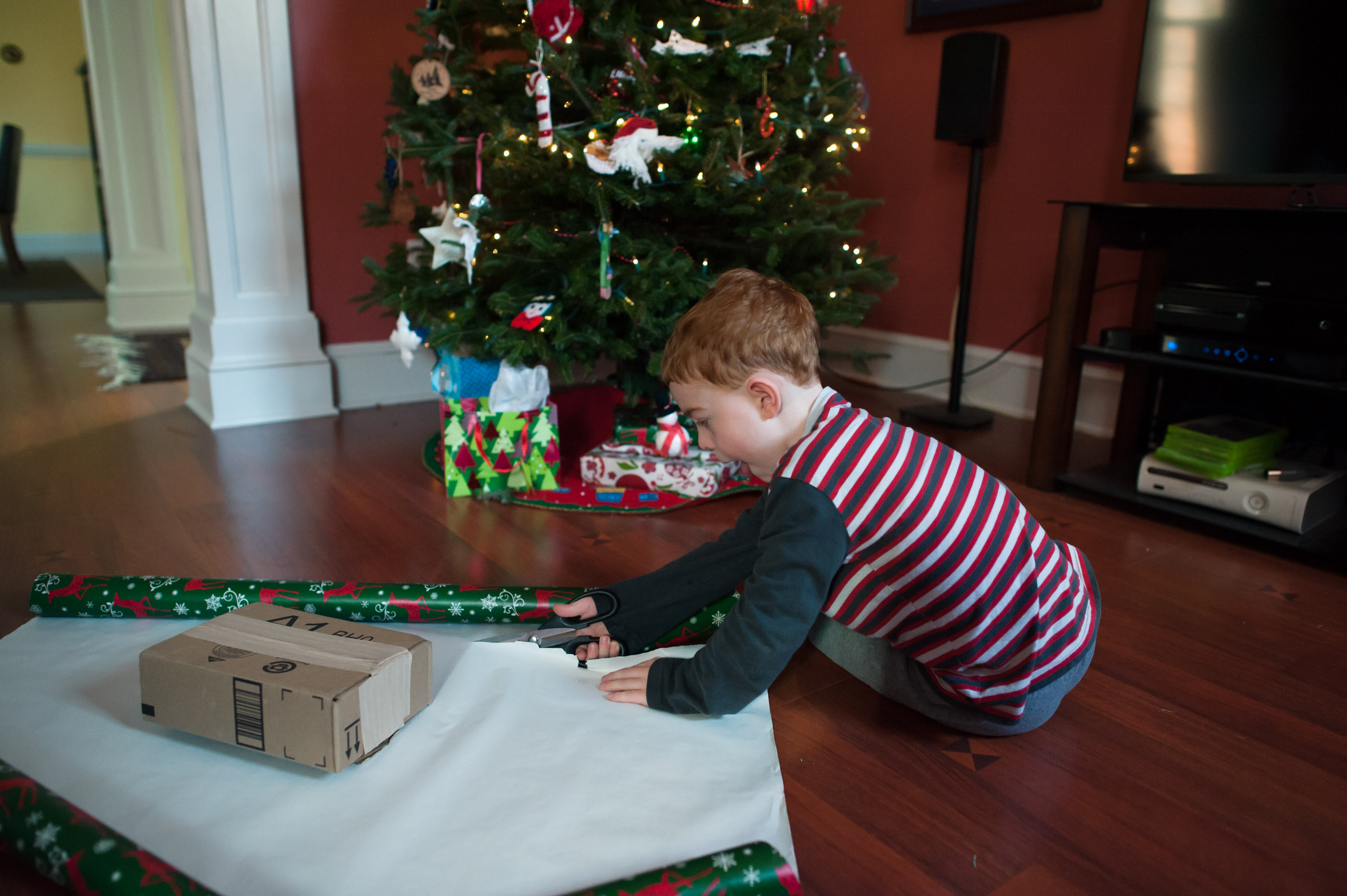 young boy wraps present - Family Documentary Photography
