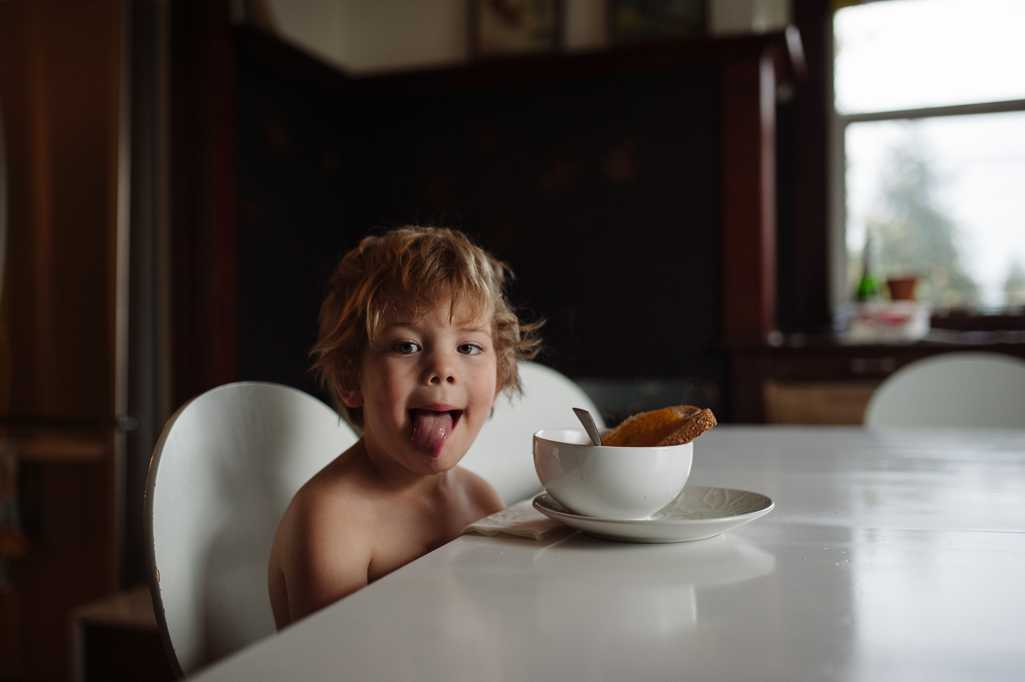 boy sticks out tongue at lunch - Family Documentary Photography