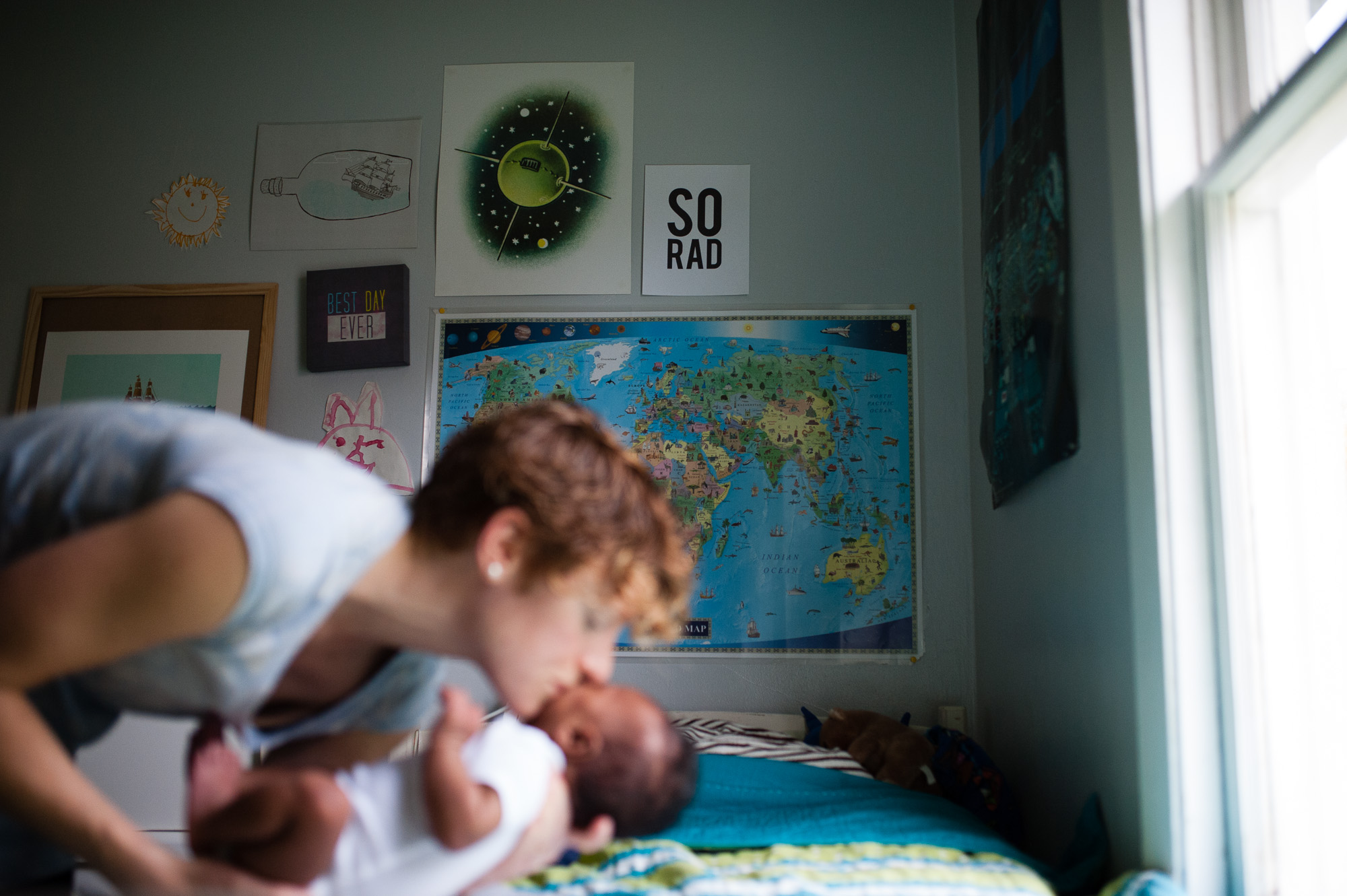 mother kissing baby in foreground - Family Documentary Photography