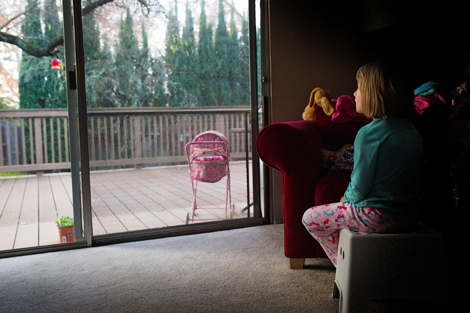 girl looks out back door - Documentary Family Photography