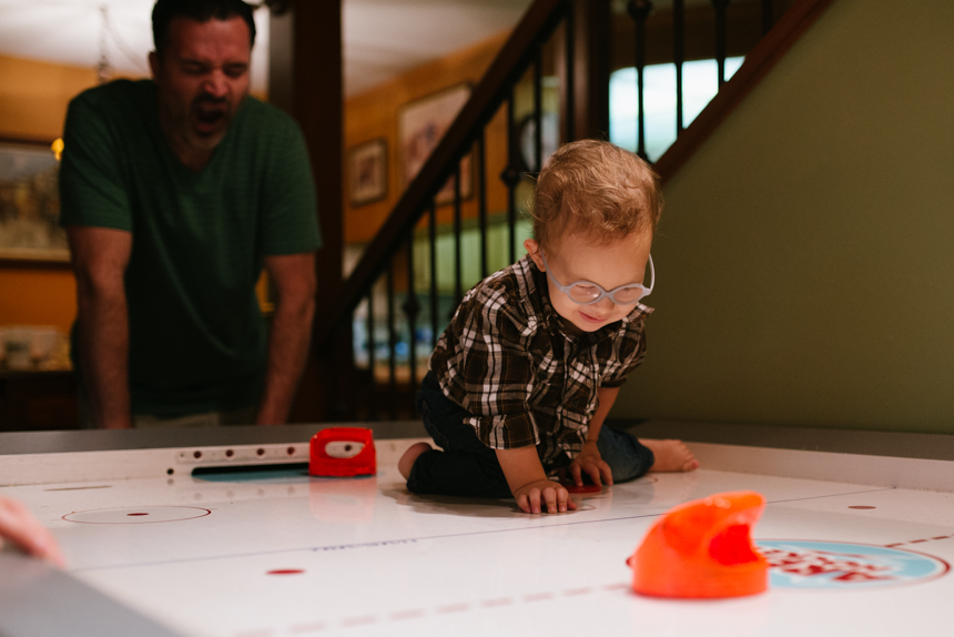 little boy on air hockey table - Documentary Family Photography