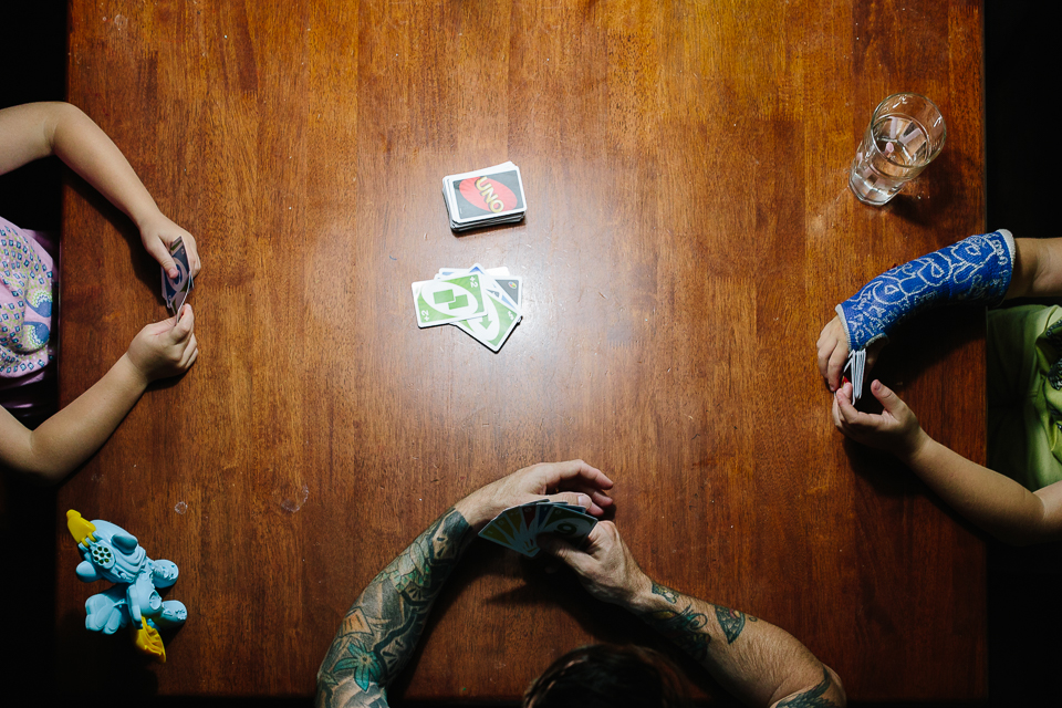 Family plays cards at kitchen table - Documentary Family Photography