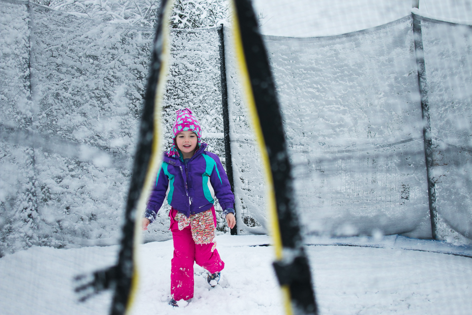 girl on snowy trampoline - Documentary Family Photography