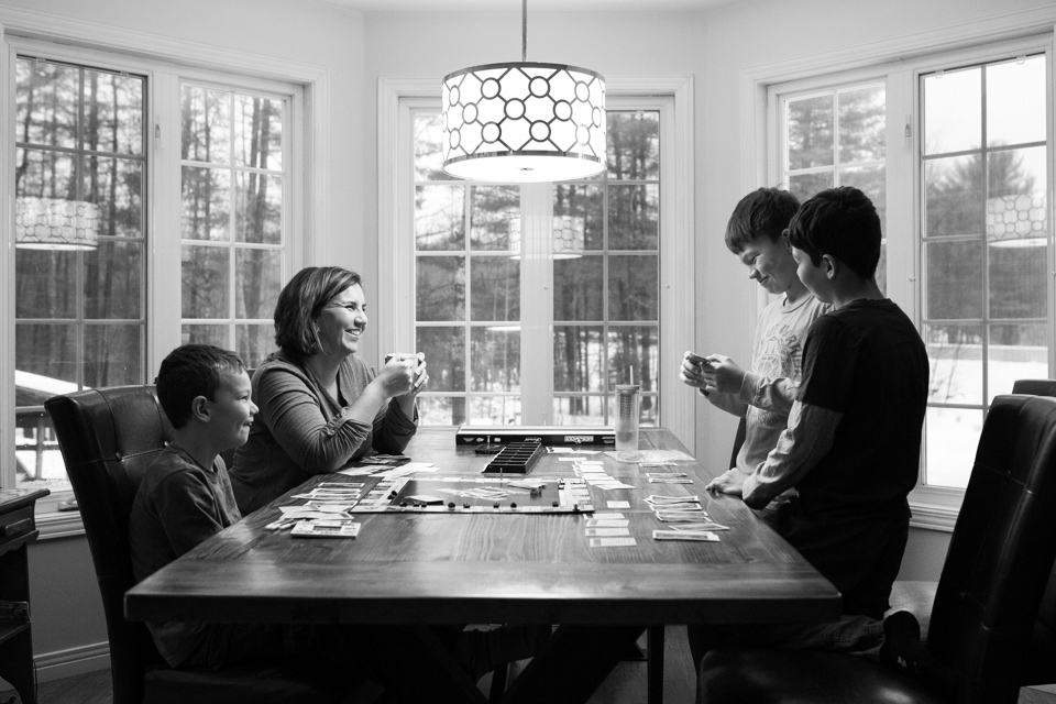 Family plays board game at table - Documentary Family Photography