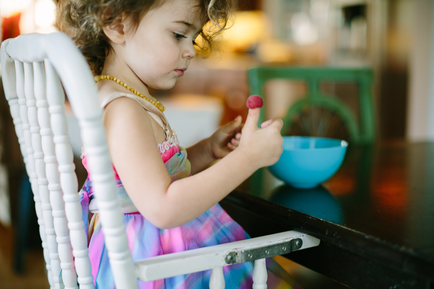 girl with raspberry on thumb - Documentary Family Photography 