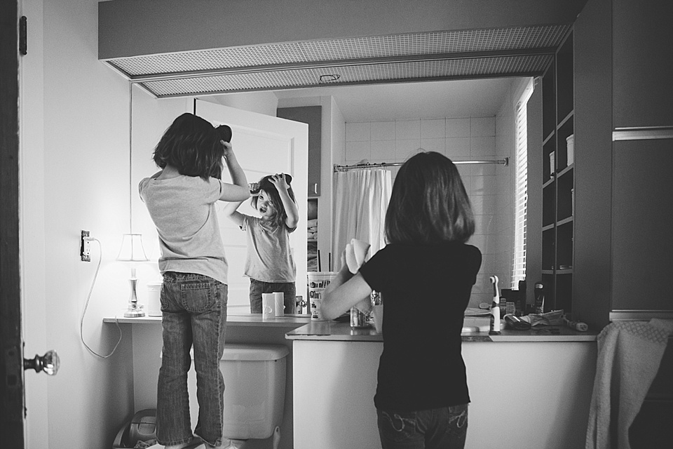Girls do hair in mirror - Documentary Family Photography