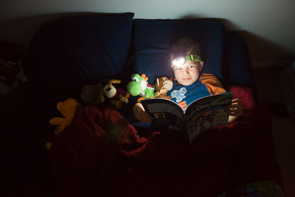 boy reads in bed - Documentary Family Photography