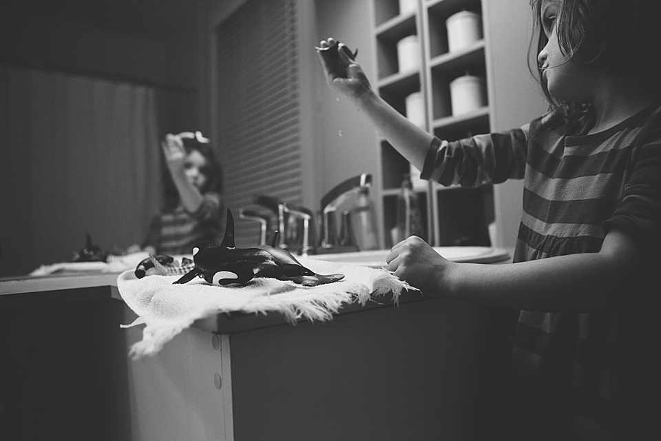 Girl with whale toys at sink - Family Documentary Photography