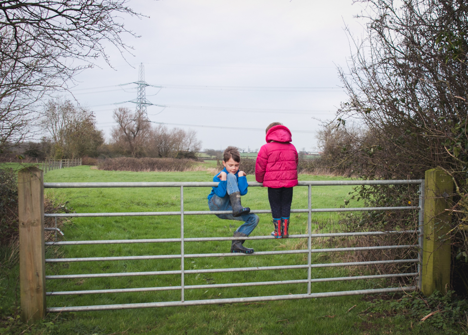 Kids climbing over fence -Family Documentary Photography