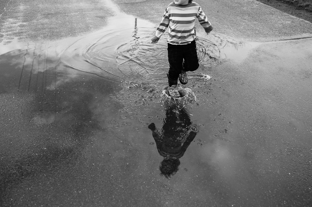 boy splashing in puddle - Documentary Family Photography