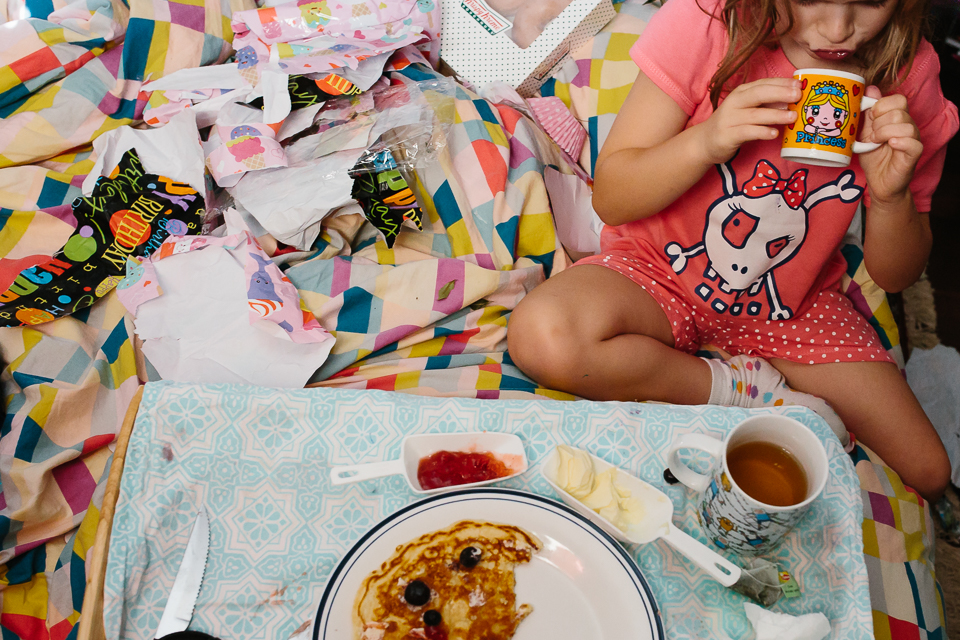 girl eats breakfast in bed - Documentary Family Photography