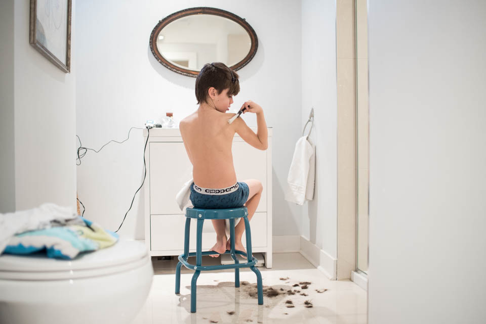 boy at bathroom sink after haircut - Documentary Family Photography