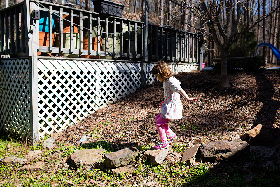 girl balances on rocks - Documentary Family Photography