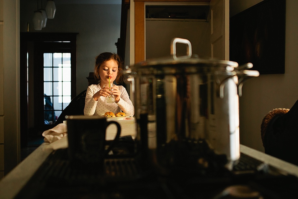 girl eats at kitchen counter - Documentary Family Photography
