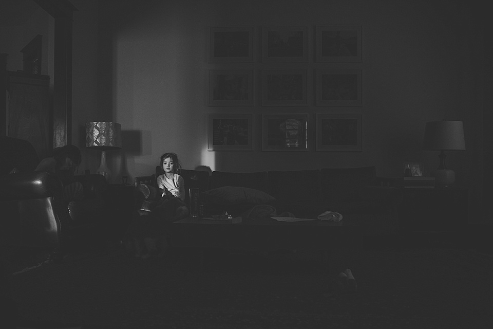 girl on couch in spot of light - Documentary Family Photography