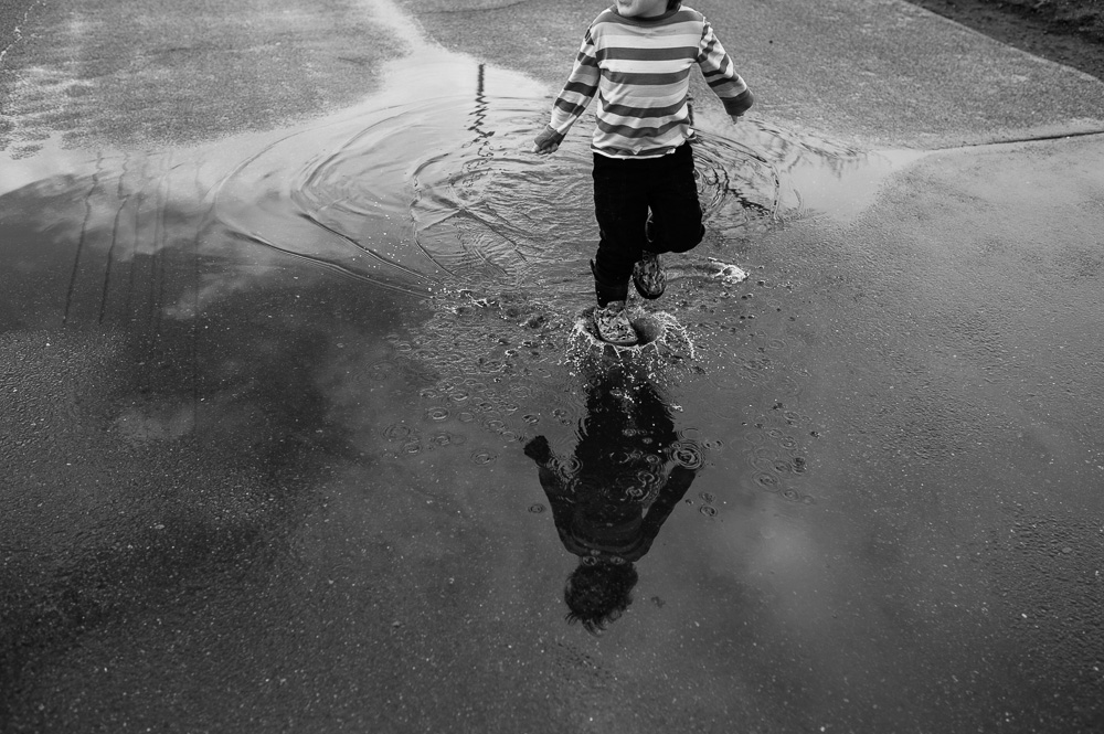 Boy splashing in puddle - Documentary Family Photography