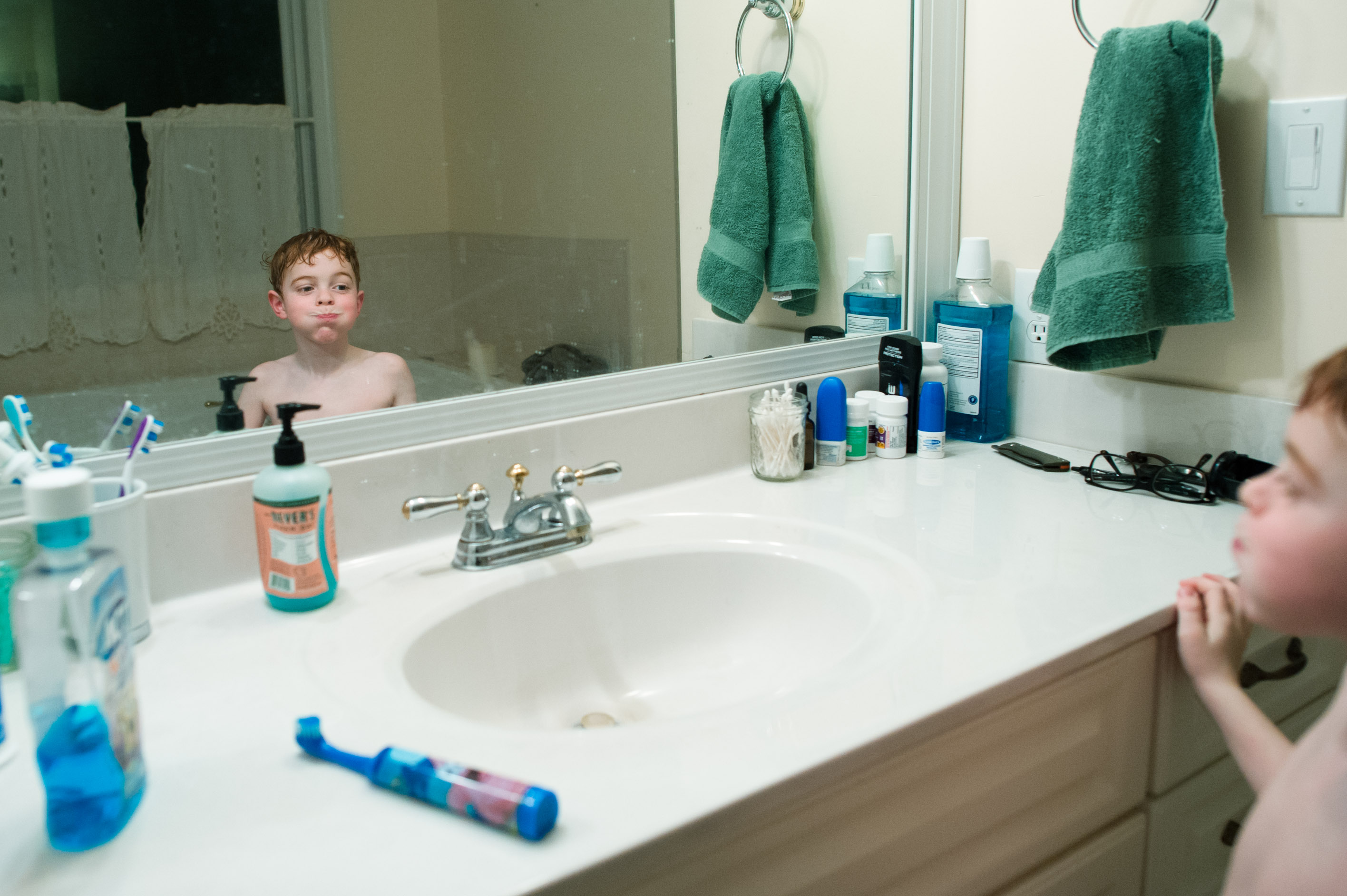 boy brushing teeth in bathroom mirror - Documentary Family Photography